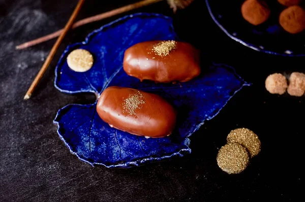 Pastel de patata de chocolate con polvo de oro en la placa azul profunda.Una obra de arte culinario — Foto de Stock