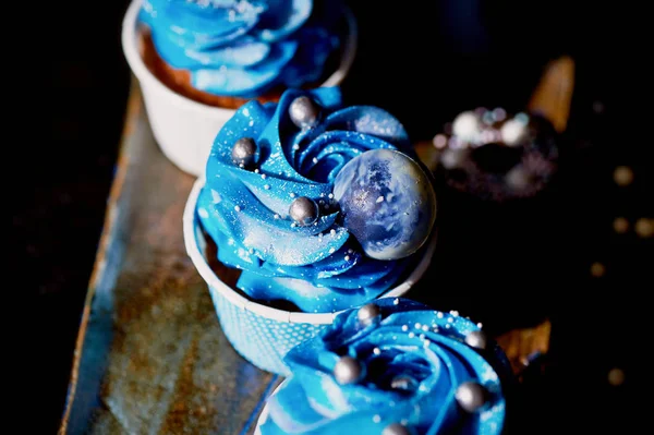 Increíbles cupcakes cósmicos azules con decoración en forma de planetas redondos.Una obra de arte culinario — Foto de Stock