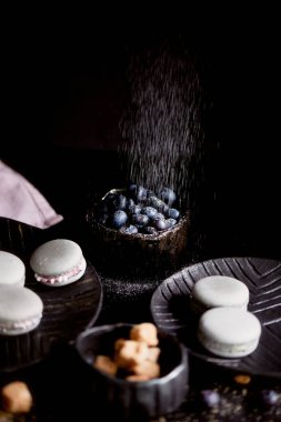 Koyu gri düzeni içinde belgili tanımlık fotoğraf. Gri pasta macaron. Makro. Pudra şekeri strewed yaban mersini.