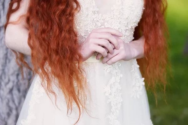 Mooie roodharige meisje met lang krullend haar in de bruid, in een lange kant jurk. Een natuurlijke schoonheid. — Stockfoto