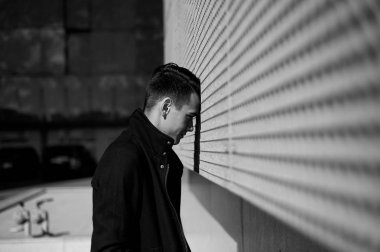 Genç adam bir çıkmaz sokak veya depresyon memnun değil. Alnını duvara yaslanmış duruyor. Siyah beyaz resim