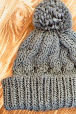 gri şapka ve eldiven bir ahşap yüzeye örme. Sonbahar ya da kış günde sıcak tutmak için bir kavramdır