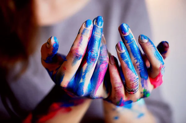 Gli artisti mano con un pennello sottile immerso brillanti pitture acriliche fluorescenti.Blu, rosa, turchese. Il concetto di creatività, ispirazione — Foto Stock