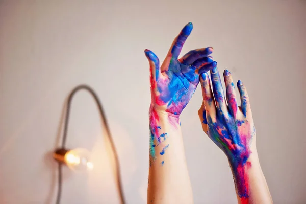 Gli artisti mano con un pennello sottile immerso brillanti pitture acriliche fluorescenti.Blu, rosa, turchese. Il concetto di creatività, ispirazione — Foto Stock