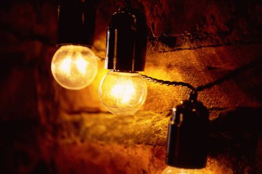 Edison ampul uzun bir tel üzerinde asılı. Sıcak sıcak sarı ışık. Retro