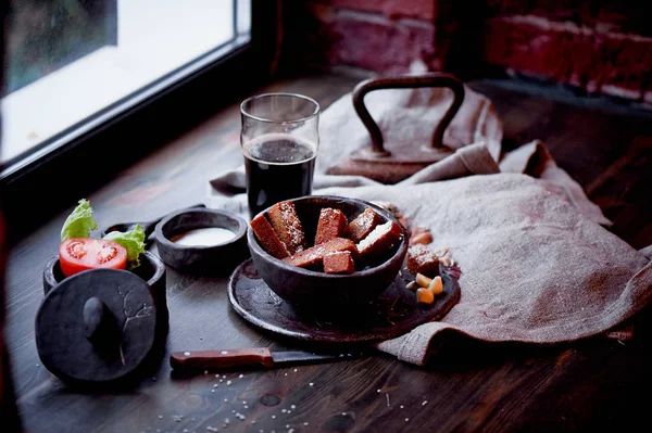 Garlic croutons in the dark interior of the pub. Hearty, quick lunch.Atmospheric photo. Dark beer. — Stock Photo, Image