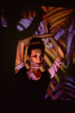 Soyut portre projektör ışığında güzel bir kız. Mor ve turuncu renkler. Uzaylı orman. Güzel, tehlikeli ve gizemli