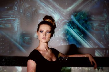 Soyut portre projektör ışığında güzel bir kız. Serin gölgeler. Güzel ve gizemli. Topuz tarzı saç.