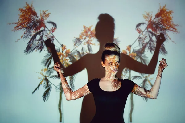 Soyut portre projektör ışığında güzel bir kız. Mimoza, yansıma dal yüzünde. Güzel ve gizemli. Topuz tarzı saç.