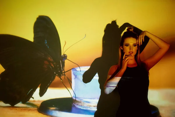 Soyut portre projektör ışığında güzel bir kız. Sıcak turuncu tonları. Siyah kelebek resmi. Kırılganlık ve güzellik duygusu. Plastik gövdeli. Güzel ve gizemli. Topuz — Stok fotoğraf
