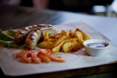 Doyurucu, yağlı yemek tablo için. Beer.German Ulusal mutfağı. Kızarmış sosis kızarmış patates ve sos ile