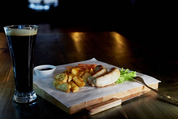 Hearty, fatty dish to the table. Beer.German national cuisine. Fried sausages with fried potatoes and sauce — Stock Photo, Image