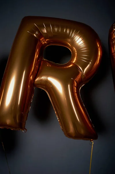 Golden balloons in the form of letters.The letter R. the Atmosphere of celebration, bachelorette party