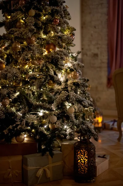 Gezellige kerstboom met kerstverlichting en dozen van presenteert. Warme kleuren, intieme twilight — Stockfoto