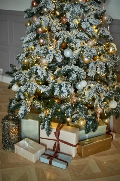 Acogedor árbol de Navidad con luces de Navidad y cajas de regalos. Colores cálidos, crepúsculo íntimo — Foto de Stock