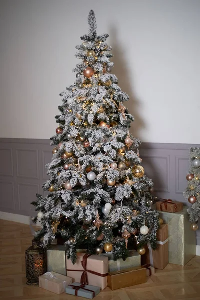 Gezellige kerstboom met kerstverlichting en dozen van presenteert. Warme kleuren, intieme twilight — Stockfoto