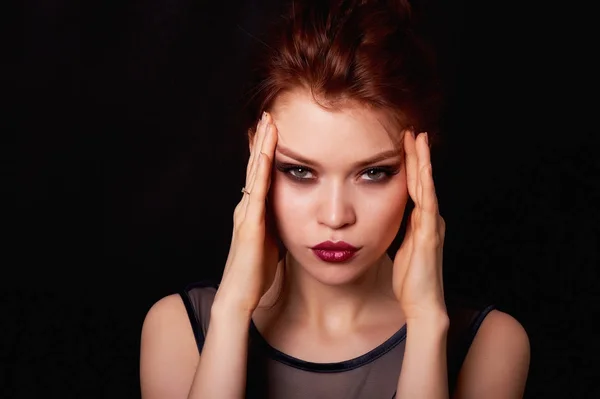 Girl in Studio on dark background. Red hair, great figure. Hands on his temples.Problems, irritability, and headache. Negative thoughts — Stock Photo, Image