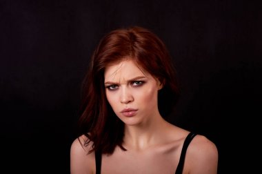 Siyah bir zemin üzerine kız Studio. Kızıl saçlı, büyük rakam. Sinirlenme ve memnuniyetsizlik Frowns.The devlet