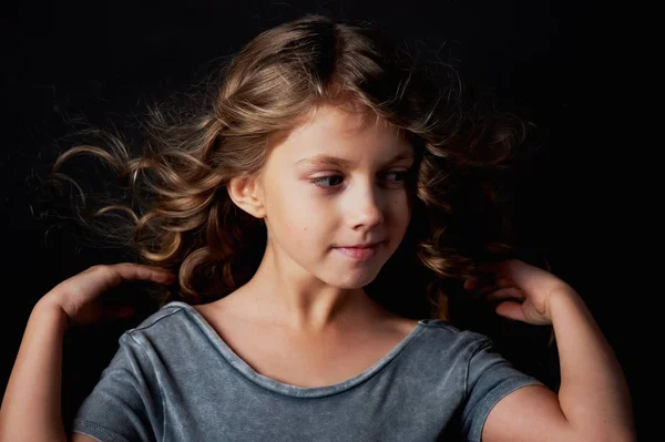 Chica rizada con el pelo largo. En el estudio sobre un fondo negro. Un cuento de hadas para niños.Vive en el marco —  Fotos de Stock