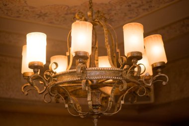 Büyük metal avize, eski sürüm sahte. Yakından. Ilık ışık