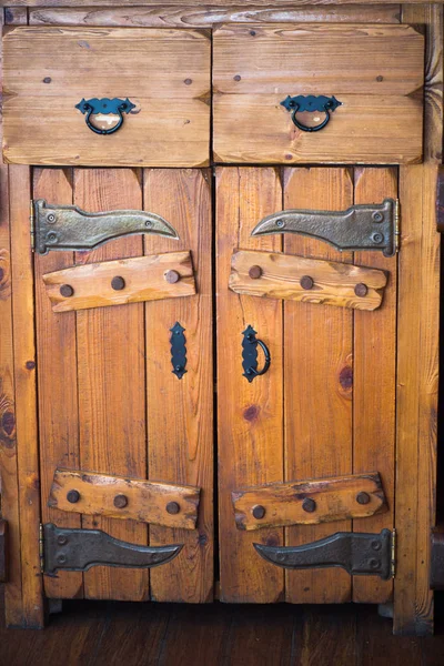 Gabinete de madera maciza antigua con puertas y cajones. Accesorios forjados de metal negro — Foto de Stock