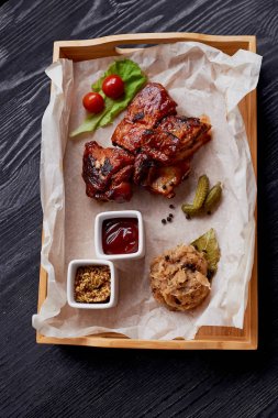 Kaburga ile lahana turşusu ızgarada pişmiş. Parşömen kağıt üzerine salatalık ve domates ile dekore edilmiş