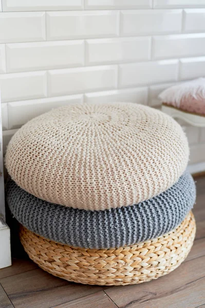 Un tas de poufs près de la cheminée, un de la rotin et deux laine tricotée.Emplacement confortable — Photo