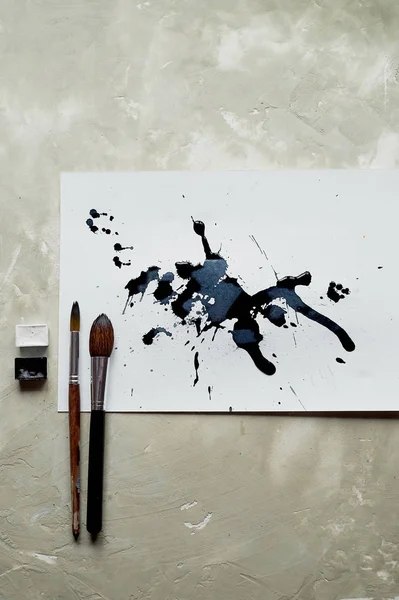 Palette de peinture en noir et blanc. une feuille de papier d'art blanc avec de l'encre de teinture noire . — Photo