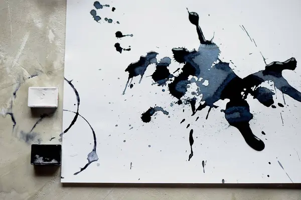Uma paleta de tinta preta e branca.uma folha de papel de arte branca com tinta preta . — Fotografia de Stock