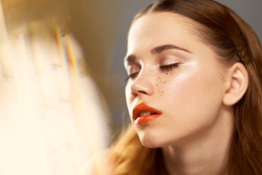 Profesyonel makyaj ile Studio, genç güzel kız portresi. Çekim güzellik. Sıcak altın parlama. Altın pul çiller. Cilt üzerinde güneşin sıcaklığını hissediyor.