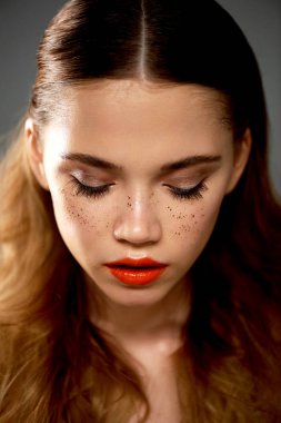 Profesyonel makyaj ile Studio, genç güzel kız portresi. Çekim güzellik. Temiz cilt güzel bir kızla Güzellik Portresi. Parlak turuncu dudaklar altın çiller