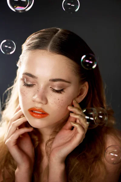 Portrait of young beautiful girl in Studio, with professional makeup.Beauty shooting.The beauty of soap bubbles. The rainbow flares — Stock Photo, Image