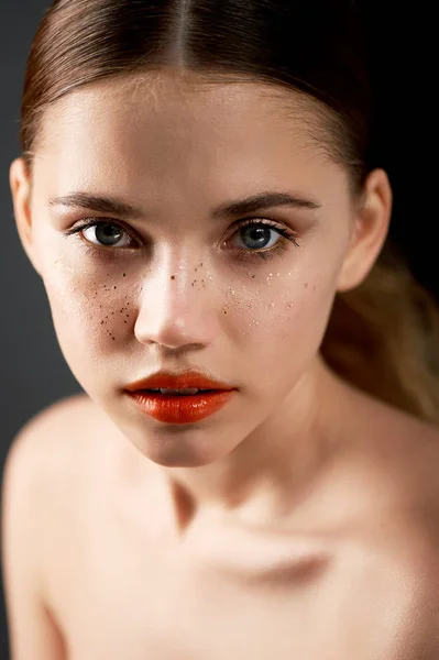 Retrato de joven hermosa chica en Studio, con maquillaje profesional.Fotografía de belleza. Retrato de belleza de una hermosa chica con la piel limpia. Labios naranja brillante pecas de oro —  Fotos de Stock