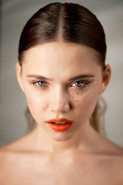 Retrato de joven hermosa chica en Studio, con maquillaje profesional.Fotografía de belleza. Retrato de belleza de una hermosa chica con la piel limpia. Labios naranja brillante pecas de oro —  Fotos de Stock