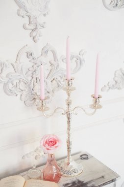 Retro Ahşap Masa oyma legs, bir kitap, bir avize pembe mum ile. Antik, entelektüel cazibe atmosferini