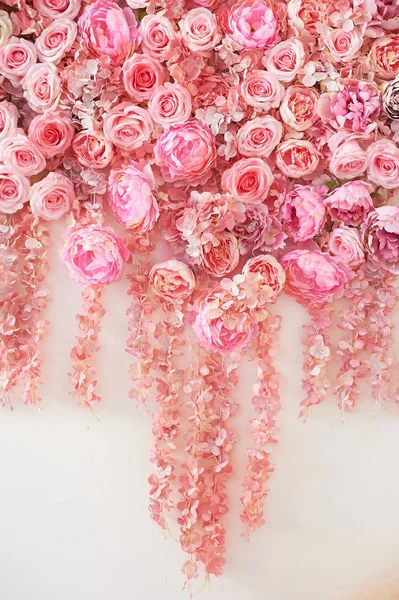 Flower garland on the wall. Dense wall of flowers. Wedding photo zone.Romantic space decor