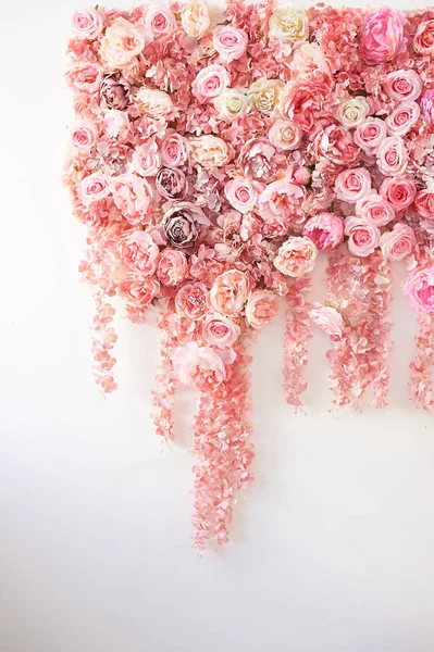 Flower garland on the wall. Dense wall of flowers. Wedding photo zone.Romantic space decor