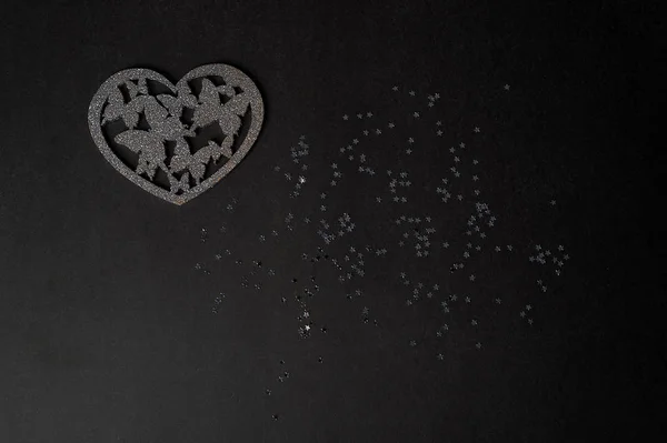 Valentines day,a Declaration of love. Silver heart with butterflies. Butterflies in the stomach. Silver heart with butterflies on a dark graphite background.