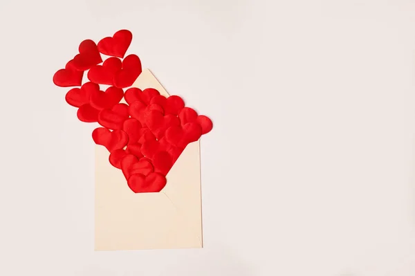 Kraft the envelope with red hearts on a white background.Congratulations on Valentines Day. Hearts fly out of the envelope.