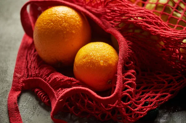 Sac à ficelle rouge avec oranges. Sans gaspillage.Macro — Photo