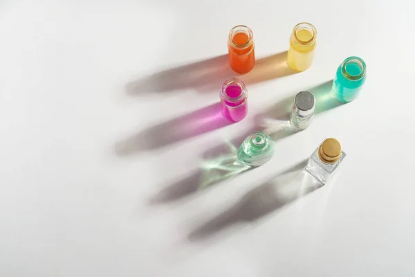 Perfume en botella transparente, aceites aromáticos. Sombra de color sobre un fondo blanco. .. Aromaterapia, producción de perfumes.Espacio para texto . — Foto de Stock