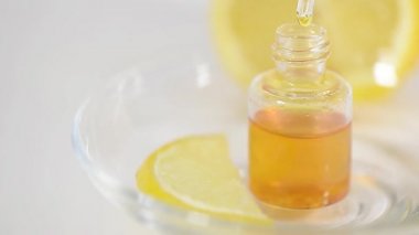 Hafif bir arka planda hafif cam bir şişede aromatik yağ. Düşüyor. Ruh yaratıyor. Spa tedavileri. Limon, limon..