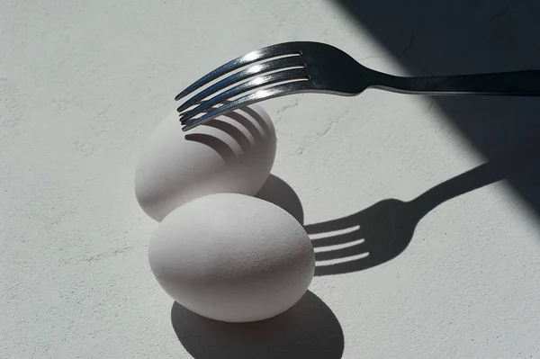 Ovo com sombra do garfo. Minimalismo. Cozinhar bolos, omeletes. Devagar. Sombras e luz . — Fotografia de Stock