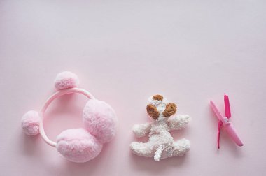 Çocuklar dünyasının kızı. Pembe arka plan, oyuncak, maşa ve balkabaklı kulaklıklar..