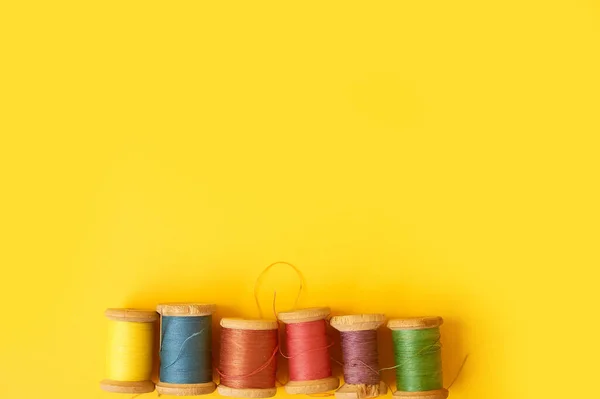 Bobinas de color con hilos en un fondo amarillo.Artesanías y costura . — Foto de Stock