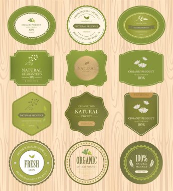 doğal etiket ve organik etiket yeşil rengi ahşap doku üzerinde kümesi. Vintage etiketleri ve rozetleri tasarım.