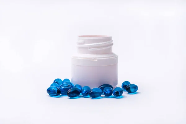 Blå piller och medicin flaska isolerad på vit bakgrund. Royaltyfria Stockbilder