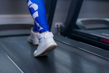 Spor salonunda koşu bandı kadın kaslı bacaklarına. Egzersiz, fitness ve sağlıklı yaşam konsepti.