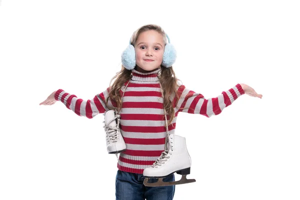 Υπέροχο μικρό γελαστό κοριτσάκι που φοράει πολύχρωμα ριγέ πουλόβερ και κόμμωση, κρατώντας πατίνια που απομονώνονται σε λευκό φόντο. Χειμωνιάτικα Ρούχα. — Φωτογραφία Αρχείου