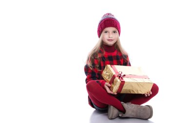 Kıvırcık saç örme kazak, atkı ve şapka Noel hediye izole beyaz arka plan üzerinde tutarak ile sevimli gülümseyen küçük kız. Kış giysileri ve Noel kavramı.